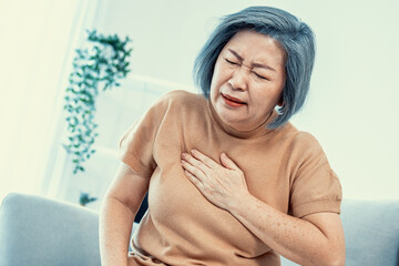 An agonizing elderly woman is experiencing chest pain. Medical attention, senior care service.