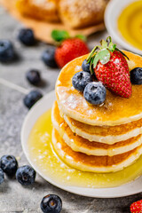 Pancakes in a plate with berries and honey. 