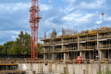 Construction site with cranes against blue sky. Industrial background. Modern skyscrapers. Unfinished construction