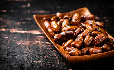Delicious dates on a wooden plate. 