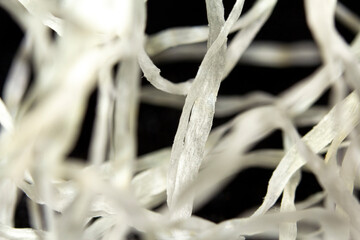A lose-up, macro image of dental floss on black background