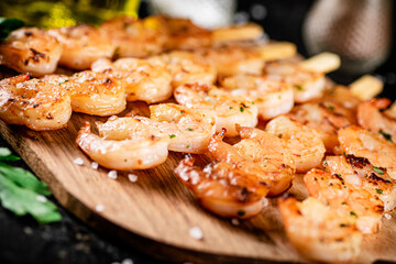 Grilled shrimp on a wooden cutting board. 