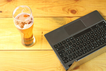 mug with beer next to laptop