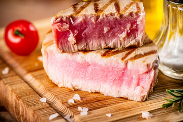 A piece of grilled tuna on a cutting board. 