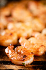 Grilled shrimp on a wooden cutting board.