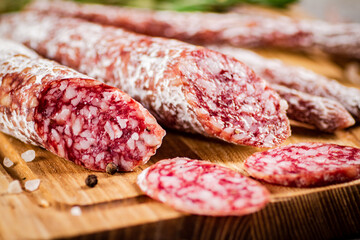 Pieces of salami sausage on a cutting board. 