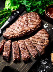 Sliced grilled steak on a cutting board.