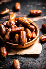 Delicious dates on a wooden plate. 