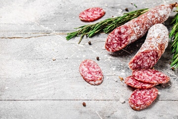 Pieces of salami sausage with sprigs of rosemary. 