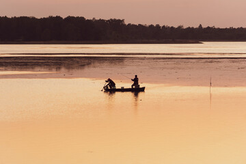 Obraz na płótnie Canvas Fisherman's boat on the river with sunset.
