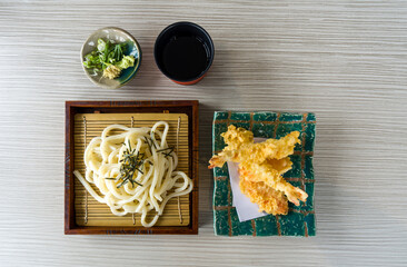Tenzaru Udon served on wooden table with a refreshing mentsuyu dipping sauce, wasabi, ginger and...