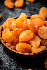 Delicious dried apricots in a wooden plate. 