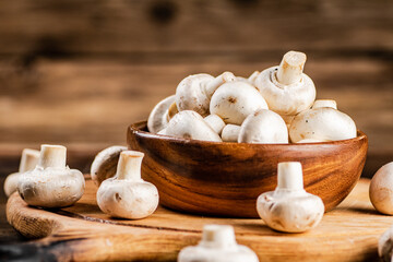 Mushrooms in a bowl on a cutting board. 
