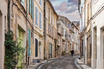 Fototapeta na wymiar A man walk in a medieval street of Arles city in France
