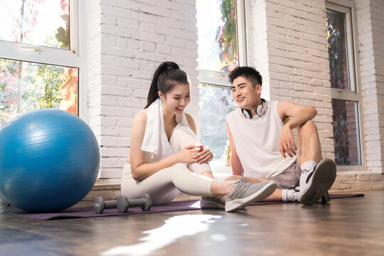 Young couple sitting on the ground to rest after workout