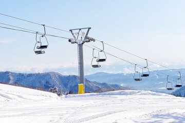 Fototapeta na wymiar An ski lift with empty chairs
