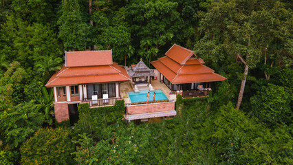 couple of men and woman on a luxury vacation at a pool villa in the jungle rainforest
