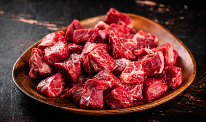 Chunks of fresh raw beef on a plate. 