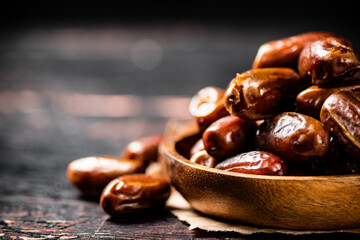 Delicious dates on a wooden plate. 