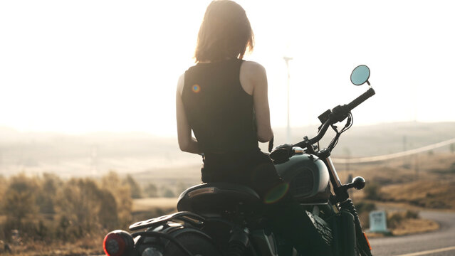 Sexy young woman riding motorcycle in suburbs