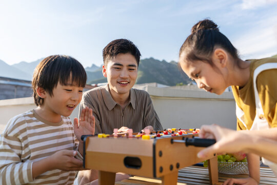 The young father and children playing outdoors table football