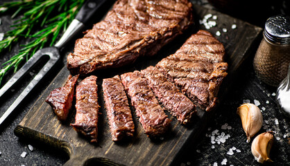 Sliced grilled steak on a cutting board.