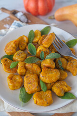 Healthy home made Pumpkin gnocchi with cheese and fresh herbs on a table