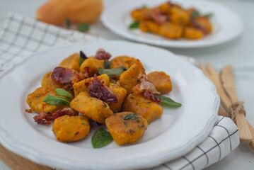 Healthy home made Pumpkin gnocchi with cheese and fresh herbs on a table