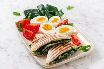 Fresh tortilla wraps with spinach and cheese on light background .  Healthy food concept. Vegetarian food.