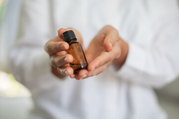 Female scientist in white medical uniform with mock up glass cosmetic jar in hands