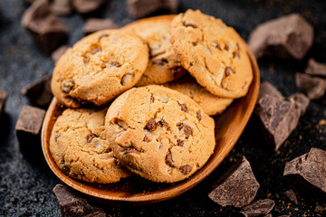 Wooden plate with cookies and pieces of milk chocolate. 
