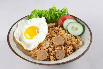 Nasi Goreng Bakso is Fried Rice with Meat Ball garnished with fresh cucumber and tomatoes slices.