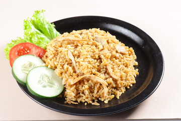 Nasi Goreng Ayam is Fried Rice with chicken meat garnished with fresh cucumber and tomatoes slices.