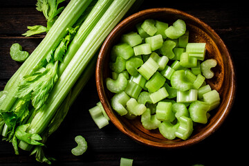 Sliced fresh celery. On a dark wooden background.