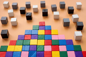 Inclusion or teambuilding concept. Pyramid of colored cubes and black and white next.