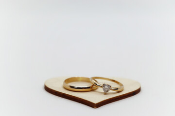 Two golden rings on a wooden heart