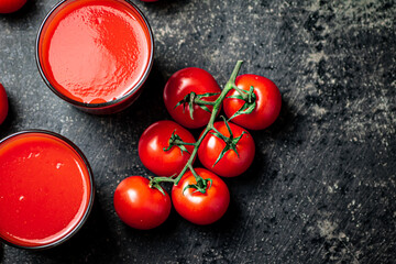 Fresh tomato juice. On a black background.