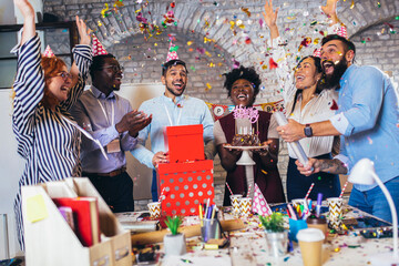 Businesspeople celebrating their colleagues birthday in office