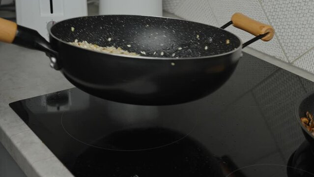 Process of cooking risotto with mushrooms. Cook mixes arborio rice in frying pan, close up. Italian cuisine dish