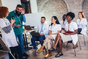 Group of happy doctors on seminar in lecture hall at hospital