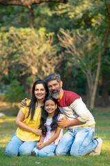 Fototapeta premium Happy indian couple with his little daughter at park.