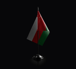 Small national flag of the Oman on a black background