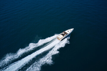 Large high speed motor white boat with people at high speed moving diagonally