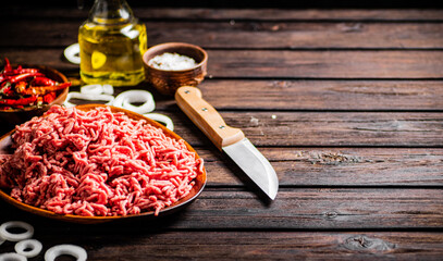 Minced meat on a plate with onion rings. 