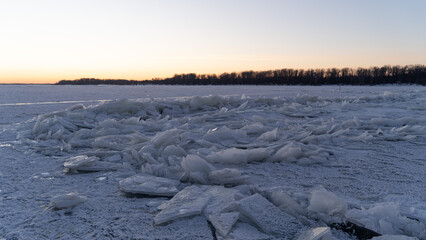 Winter sunset on the big river, hummocks in the rays of the sun.