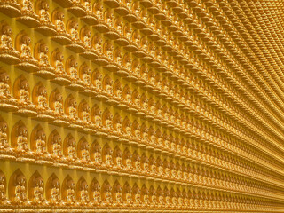 Ten thousand of gold mini buddha statues perfect arrange at Nam Rit Guanyin temple, Uttaradit province, Thailand.