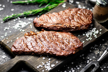 Grill steak on a wooden cutting board.