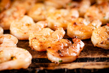 Grilled shrimp on a wooden cutting board.