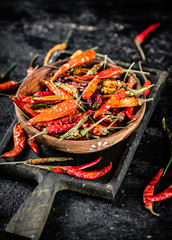 Multicolored pods of dried chili peppers on a cutting board. 