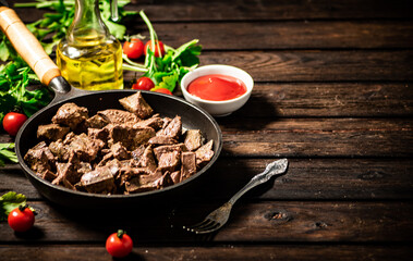 A frying pan with cooked liver on the table. 